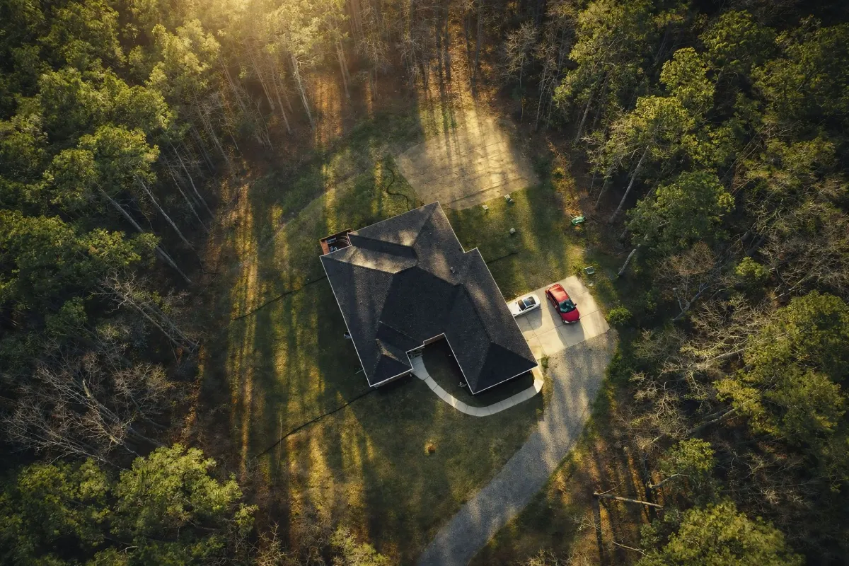 Aerial view of house nestled in cleared forest